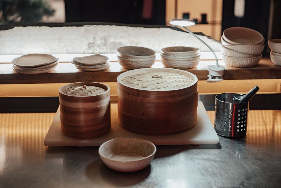Stylish bamboo steamers and bowls in a contemporary kitchen setting, perfect for food presentation concepts.